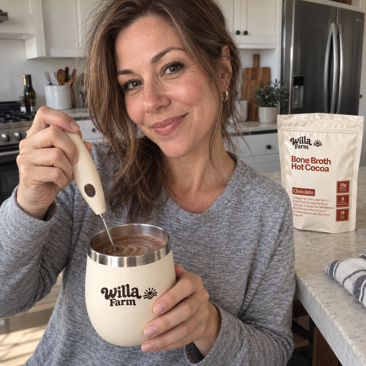 Preparing warm Willa Farm cocoa with a handheld frother