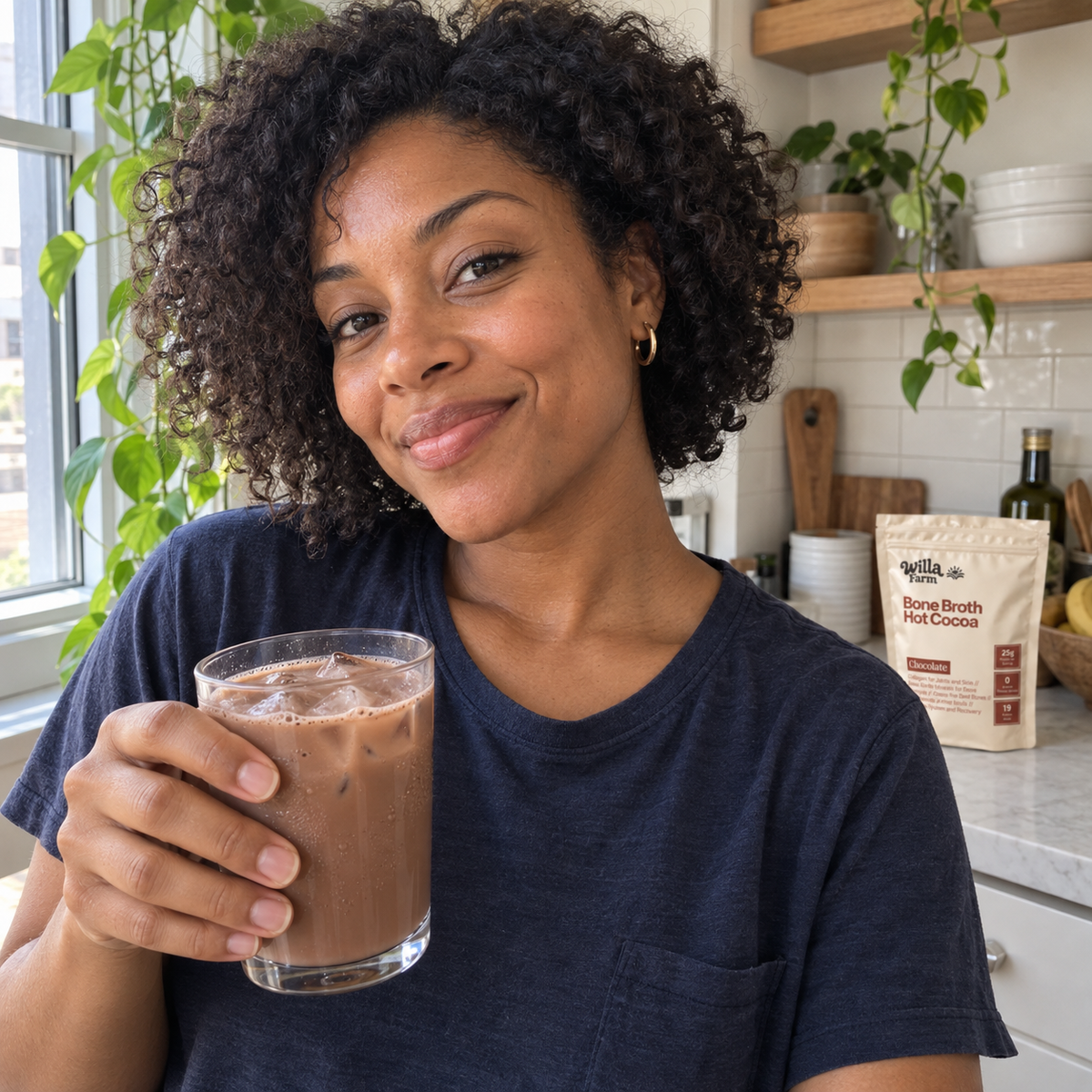 A glass of iced Willa Farm cocoa beside a kitchen window